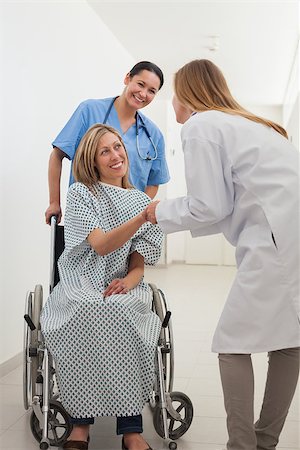 Smiling female patient shaking hand of doctor with nurse in hospital corridor Stock Photo - Budget Royalty-Free & Subscription, Code: 400-06799595