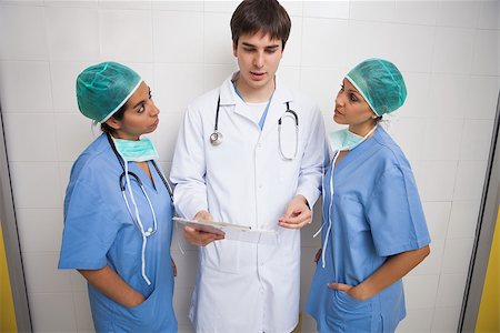 Doctor talking to two nurses either side of him Stock Photo - Budget Royalty-Free & Subscription, Code: 400-06799630