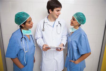 Doctor talks to smiling nurses in hospital room Stock Photo - Budget Royalty-Free & Subscription, Code: 400-06799631
