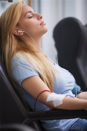 Woman donating blood and listening to music device in hospital Stock Photo - Budget Royalty-Free & Subscription, Code: 400-06799788