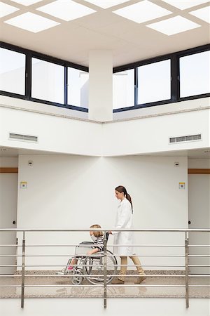 Female doctor pushing child with neck brace in wheelchair in hospital corridor Stock Photo - Budget Royalty-Free & Subscription, Code: 400-06800647