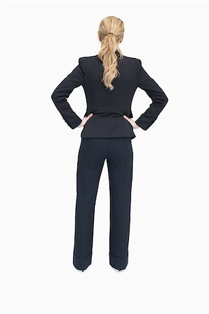 executive standing white background - Businesswoman standing with back facing and hands on hip Photographie de stock - Aubaine LD & Abonnement, Code: 400-06802299