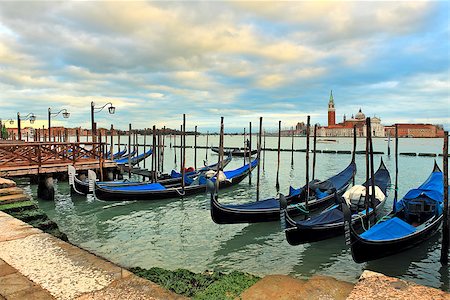 simsearch:400-08093706,k - Gondolas moored in a row at wooden pier on Grand Canal against background of San Giorgio Maggiore church in Venice, Italy. Stock Photo - Budget Royalty-Free & Subscription, Code: 400-06857071