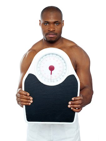 simsearch:400-06482604,k - Attractive athlete showing weighing scale against white background Stock Photo - Budget Royalty-Free & Subscription, Code: 400-06859204