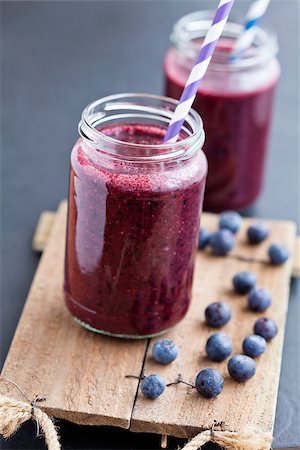 food or drink - Closeup of blueberry smoothies in glasses with striped straws on wooden serving tray with blueberries Foto de stock - Super Valor sin royalties y Suscripción, Código: 400-06852469