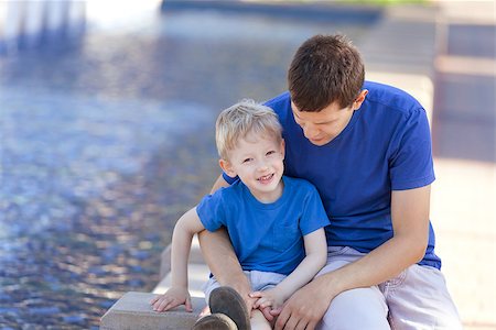 happy adorable boy and his father sitting and hugging together; smiling family of two spending time together Stock Photo - Budget Royalty-Free & Subscription, Code: 400-06852706