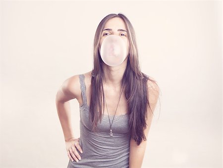 Young woman blowing a bubble gum on pink background Stock Photo - Budget Royalty-Free & Subscription, Code: 400-06853511