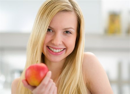 Portrait of smiling teenager girl with apple in kitchen Foto de stock - Super Valor sin royalties y Suscripción, Código: 400-06853563