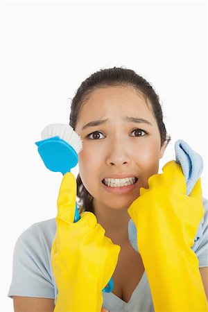 simsearch:400-06863660,k - Stressed woman holding scrubbing brush and rag wearing rubber gloves Stock Photo - Budget Royalty-Free & Subscription, Code: 400-06866416
