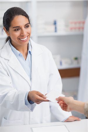 Smiling pharmacist handing paper to a customer in a hospital Stock Photo - Budget Royalty-Free & Subscription, Code: 400-06867990