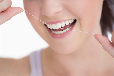 dental floss - Woman using dental floss against white background Stock Photo - Budget Royalty-Free & Subscription, Code: 400-06868446