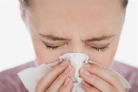 Woman with eyes closed blowing her nose against white background Stock Photo - Budget Royalty-Free & Subscription, Code: 400-06868933