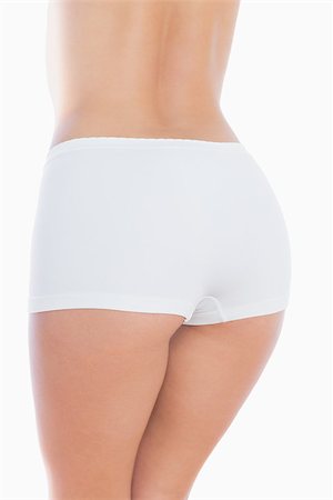 pot belly - Rear view of fit woman in shorts over white background Foto de stock - Super Valor sin royalties y Suscripción, Código: 400-06869813