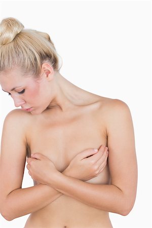 Naked young woman covering her breasts with hands over white background Photographie de stock - Aubaine LD & Abonnement, Code: 400-06869919
