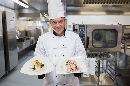 Smiling cook holding two chicken plates in the kitchen Stock Photo - Budget Royalty-Free & Subscription, Code: 400-06863231