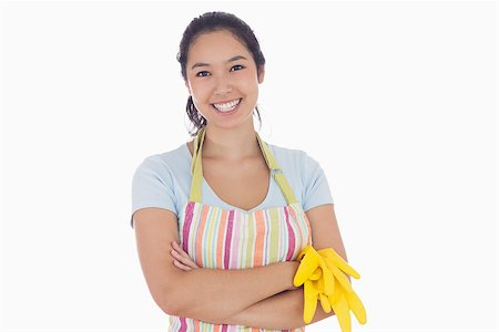simsearch:400-06863660,k - Standing woman smiling and wearing apron while holding rubber gloves Stock Photo - Budget Royalty-Free & Subscription, Code: 400-06863558
