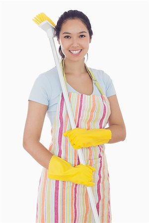 simsearch:400-06863660,k - Smiling woman in yellow gloves with a broom on her shoulder Stock Photo - Budget Royalty-Free & Subscription, Code: 400-06863581
