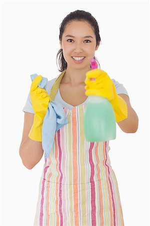 simsearch:400-06863660,k - Smiling woman in apron holding out spray bottle Stock Photo - Budget Royalty-Free & Subscription, Code: 400-06863592