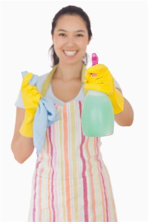 simsearch:400-06863660,k - Happy woman in apron and rubber gloves holding out spray bottle Stock Photo - Budget Royalty-Free & Subscription, Code: 400-06863593
