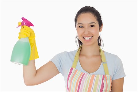 simsearch:400-06863660,k - Young woman holding a window cleaner and smiling in apron and rubber gloves Stock Photo - Budget Royalty-Free & Subscription, Code: 400-06863620