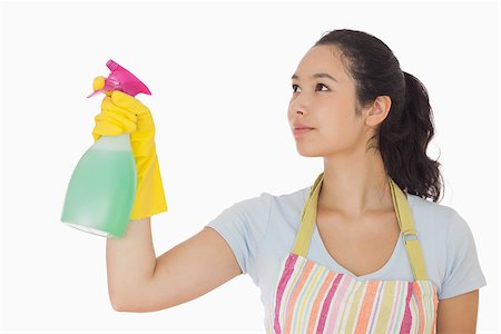 simsearch:400-06863660,k - Young woman spraying cleaner in rubber gloves and apron Stock Photo - Budget Royalty-Free & Subscription, Code: 400-06863621