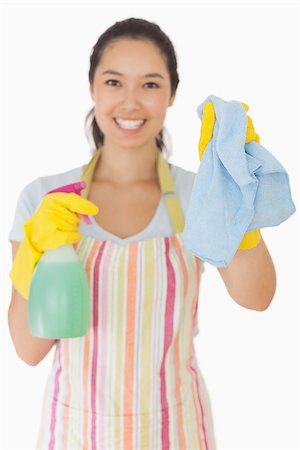 simsearch:400-06863660,k - Smiling young woman holding up rag and spray bottle in apron and rubber gloves Stock Photo - Budget Royalty-Free & Subscription, Code: 400-06863642