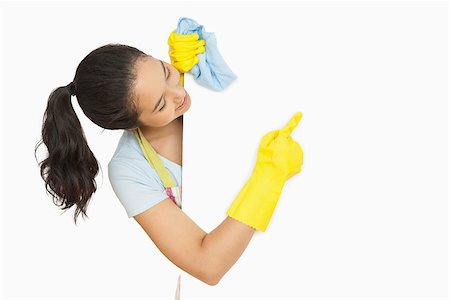 simsearch:400-06863660,k - Happy woman pointing to white surface she is cleaning wearing rubber gloves and apron Stock Photo - Budget Royalty-Free & Subscription, Code: 400-06863661