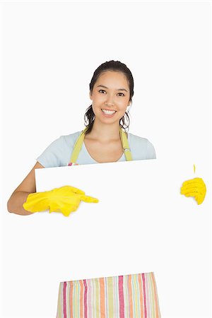 simsearch:400-06863660,k - Smiling woman in cleaning clothes pointing to white board she is holding Stock Photo - Budget Royalty-Free & Subscription, Code: 400-06863674