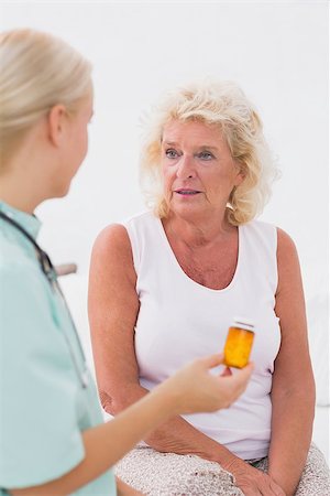 doctor patient talking senior tablet - Doctor talking about a pill bottle to her patient at home Stock Photo - Budget Royalty-Free & Subscription, Code: 400-06874485