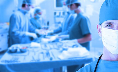 Portrait of a doctor standing in operating room in front of an operation on a blue background Stock Photo - Budget Royalty-Free & Subscription, Code: 400-06875910