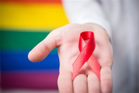 equality background hands - Man holding red awareness ribbon on rainbow background Stock Photo - Budget Royalty-Free & Subscription, Code: 400-06876233