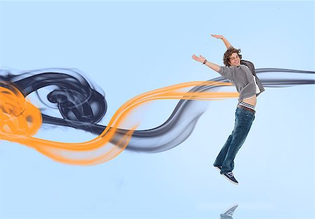 smoking teen boys - Young man jumping for joy with yellow and navy smoke trails on blue background Stock Photo - Budget Royalty-Free & Subscription, Code: 400-06877086