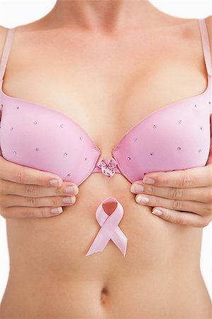 simsearch:400-07835111,k - Closeup of woman in bra with breast cancer awareness ribbon over white background Stock Photo - Budget Royalty-Free & Subscription, Code: 400-06870718