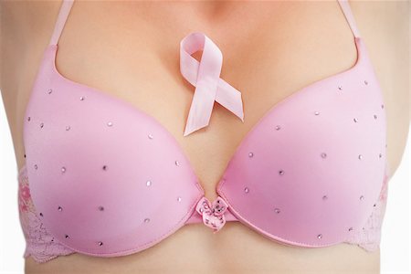 simsearch:400-07835111,k - Closeup of woman in bra with breast cancer awareness ribbon over white background Stock Photo - Budget Royalty-Free & Subscription, Code: 400-06870722