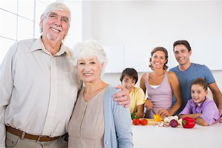 Grandparents standing by kitchen counter with family behind them Stock Photo - Budget Royalty-Free & Subscription, Code: 400-06872822