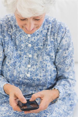 phone one person adult smile elderly - Close up on elderly smiling woman using a smartphone Stock Photo - Budget Royalty-Free & Subscription, Code: 400-06873114