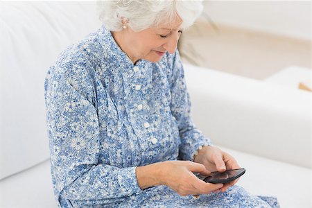 phone one person adult smile elderly - Elderly cheerful woman using a smartphone on a sofa Stock Photo - Budget Royalty-Free & Subscription, Code: 400-06873115