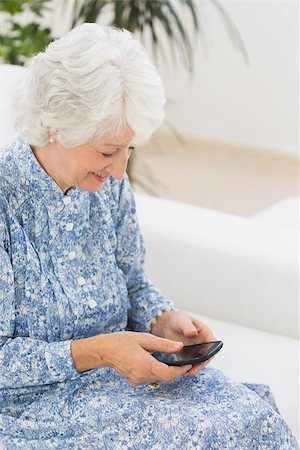phone one person adult smile elderly - Elderly happy woman using a smartphone on a sofa Stock Photo - Budget Royalty-Free & Subscription, Code: 400-06873116