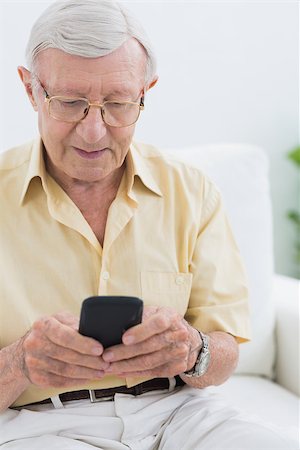 phone one person adult smile elderly - Calm elderly man using his smartphone in the living room Stock Photo - Budget Royalty-Free & Subscription, Code: 400-06873144