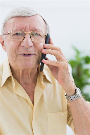 phone one person adult smile elderly - Smiling elderly man calling someone in the living room Stock Photo - Budget Royalty-Free & Subscription, Code: 400-06873147