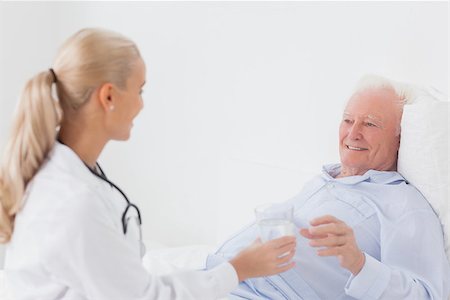 Doctor handing glass of water to elderly patient Stock Photo - Budget Royalty-Free & Subscription, Code: 400-06873621