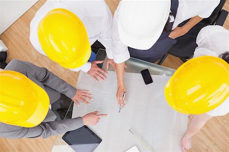 Team looking at a construction plan with hard hats in office Stock Photo - Budget Royalty-Free & Subscription, Code: 400-06873837
