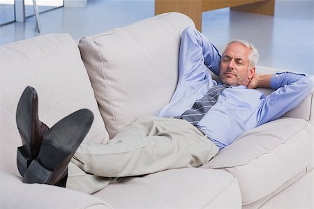 sleeping man foot - Businessman lying on sofa with his feet up in the office Stock Photo - Budget Royalty-Free & Subscription, Code: 400-06884803