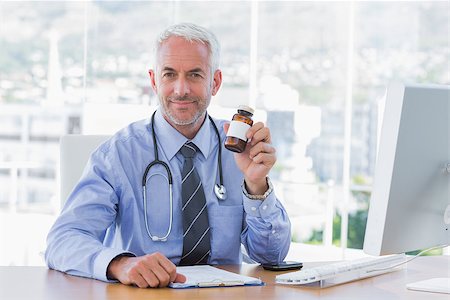 Doctor holding medicine jar in the office Stock Photo - Budget Royalty-Free & Subscription, Code: 400-06884974