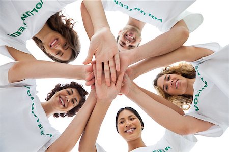 Cheerful group of volunteers putting hands together on white background Stock Photo - Budget Royalty-Free & Subscription, Code: 400-06885203