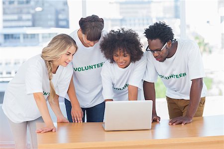 Volunteers working together on a laptop in their office Stock Photo - Budget Royalty-Free & Subscription, Code: 400-06885705