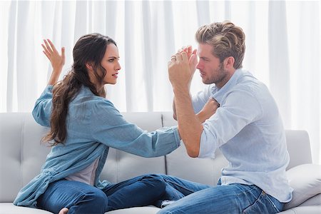 Upset woman about to slap her partner the living room Stock Photo - Budget Royalty-Free & Subscription, Code: 400-06886455