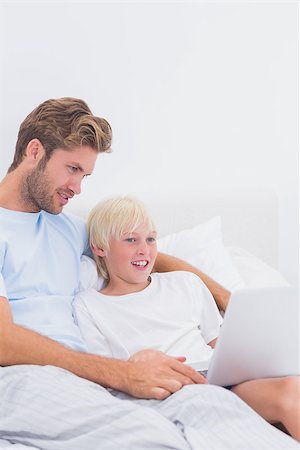 simsearch:400-06872329,k - Father and his son using a laptop in bed Stock Photo - Budget Royalty-Free & Subscription, Code: 400-06886535