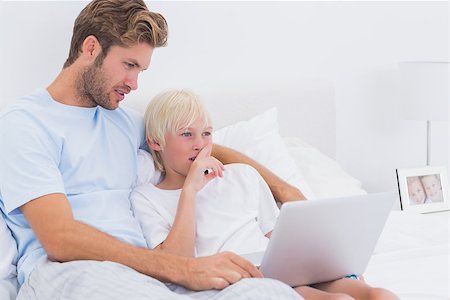 simsearch:400-06872329,k - Handsome father and his son using a laptop in bed Stock Photo - Budget Royalty-Free & Subscription, Code: 400-06886536