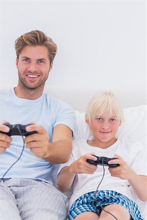 simsearch:400-06872329,k - Happy father and son playing video games in bed Stock Photo - Budget Royalty-Free & Subscription, Code: 400-06886546